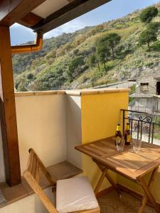 a table and chairs on a balcony with a view at Casa zia Vincenzina in Casalvecchio Siculo