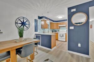 a kitchen with blue and white walls and a wooden table at Fenwick Woods OC in Ocean City