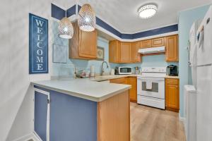 a kitchen with wooden cabinets and white appliances at Fenwick Woods OC in Ocean City