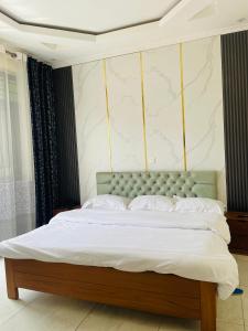 a bedroom with a large bed with white sheets and pillows at Kigali Clever Homes Villa in Kigali