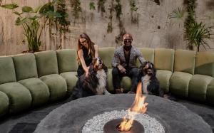 a couple and two dogs sitting next to a fire pit at Volga, Member of Preferred Hotels & Resorts in Mexico City