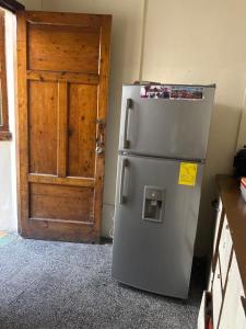 a refrigerator in a kitchen next to a door at Albergue Happy Backpacker in Cuenca