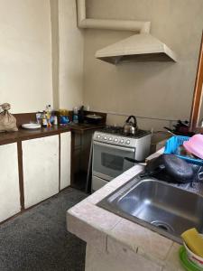 a kitchen with a sink and a stove at Albergue Happy Backpacker in Cuenca