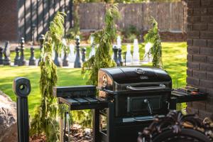 a black grill sitting in a yard with a park at Sherlock Home in Czarnówiec