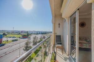 a balcony with a cross and a view of a street at appartement chaleureux essaouira in Essaouira