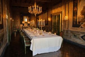 a dining room with a long table and a chandelier at VesConte Residenza D'epoca dal 1533 in Bolsena