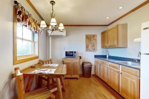 a kitchen with wooden cabinets and a table and a refrigerator at Cabin 2: Lakeside in Murphysboro in Etherton