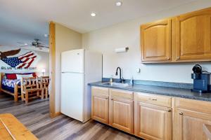 a kitchen with a white refrigerator and wooden cabinets at Pet Friendly! Countryside Couples Stay in Illinois in Etherton +17 photos