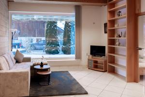 a living room with a couch and a large window at Haus Treff in Weissenbach am Lech
