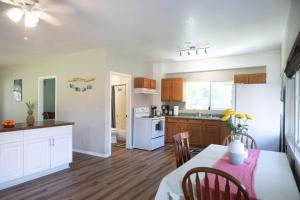 a kitchen with a table and a dining room at North Shore Bungalow in Mokuleia