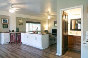 a kitchen with white cabinets and a counter top at North Shore Bungalow in Mokuleia +8 photos