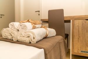 a pile of towels sitting on top of a bed at B&B Conero Hermitage in Marcelli