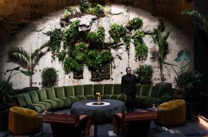 a man standing in a room with a green couch at Volga, Member of Preferred Hotels & Resorts in Mexico City