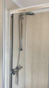 a shower door with a shower head in a bathroom at 10 Berth Caravan - Meadow View in Skegness