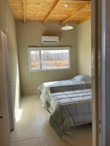 a bedroom with a bed and a window at Ancar Añelo in Añelo
