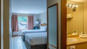 a hotel room with two beds and a sink at Cahilty #302 in Sun Peaks