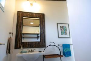 a bathroom with a sink and a mirror at North Shore Studio in Mokuleia