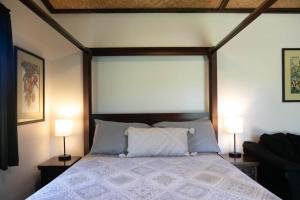 a bedroom with a bed with two lamps on either side at North Shore Studio in Mokuleia +5 photos