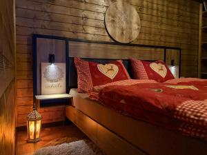 a bedroom with a bed with red pillows and a clock at Sunny Garden House in Martinske Hole