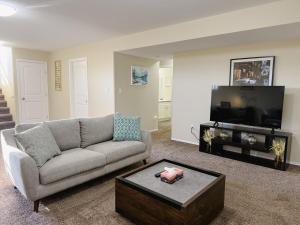 a living room with a couch and a flat screen tv at Spacious 4BR with King Suite - Garage - Netflix in Lloydminster