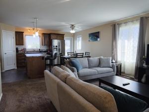 a living room with a couch and a kitchen at Spacious 4BR with King Suite - Garage - Netflix in Lloydminster