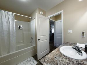 a bathroom with a sink and a shower and a toilet at Spacious 4BR with King Suite - Garage - Netflix in Lloydminster