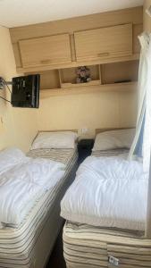 two twin beds in a room with at 10 Berth Caravan - Meadow View in Skegness