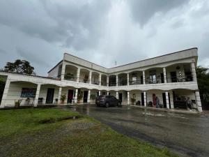 a white building with a car parked in a parking lot at mansion cafetera in Quimbaya