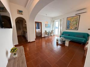 a living room with a green couch and a table at Maison Raphael Positano in Positano