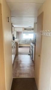 a small room with a kitchen and a living room at 10 Berth Caravan - Meadow View in Skegness