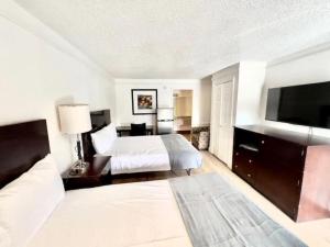 a hotel room with a bed and a flat screen tv at Airport Inn in Tulsa