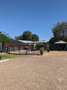 a park with a fence and a pool at Kaputar Motel in Narrabri