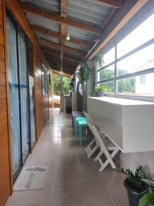 a hallway with chairs and a table and windows at Casa Flores do Campo in Florianópolis