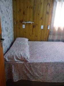 a small bed in a room with wooden walls at Casa Flores do Campo in Florianópolis +7 photos