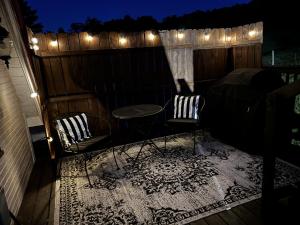 two chairs and a table on a balcony with lights at Meadowview Guest House in Hillsboro