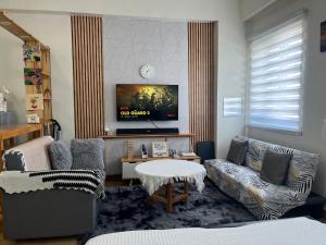 a living room with a couch and a tv at Aras Solace Place in Trece Martires