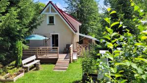a small cottage with a deck and a house at Domek Klimaty- Kamieńczyk in Międzylesie