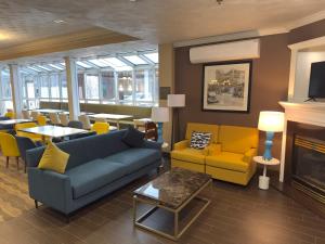 a living room with a couch and chairs and a fireplace at Comfort Suites Scranton near Montage Mountain in Scranton
