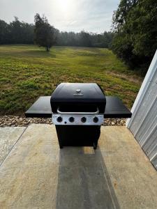 a grill sitting on a patio next to a field at Sunset in Hillsboro