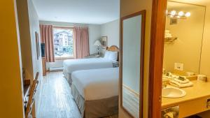 a hotel room with two beds and a sink at Cahilty #212 home in Sun Peaks