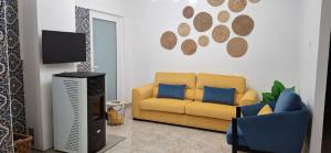 a living room with a yellow couch and a tv at Ribeiro´s House in Gafanha da Nazaré