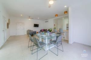 a dining room and living room with a table and chairs at Walk to 5th Ave & Beach - Pools, Balcony & Parking in Playa del Carmen +27 photos
