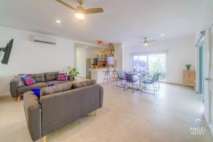 a living room with a couch and a table at Walk to 5th Ave & Beach - Pools, Balcony & Parking in Playa del Carmen