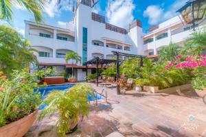 a resort with a swimming pool and a building at Walk to 5th Ave & Beach - Pools, Balcony & Parking in Playa del Carmen