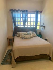 ein Schlafzimmer mit einem großen Bett und einem Fenster in der Unterkunft El Oasis in Chelem + 23 Fotos