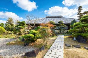 a japanese garden in front of a house at Kansai Airport Hotel Pine Villa in Kansai International Airport
