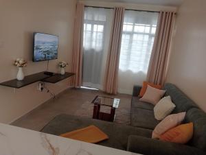 a living room with a couch and a tv at Shanvinhomes -1 bedroom Apartment in Skuta-Nyeri Town in Nyeri