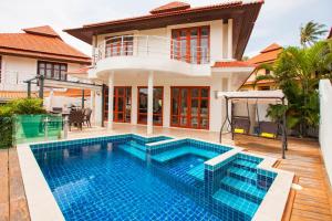 a villa with a swimming pool in front of a house at Smile House Villa in Thong Son Beach