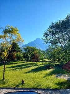 a view of a field with mountains in the background at Počitniška hiša Nad Sočo in Bovec +5 photos
