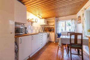 a kitchen with white cabinets and a table with chairs at KRO891-Hallaryd-Kalvshult-8 in Hallaryd
